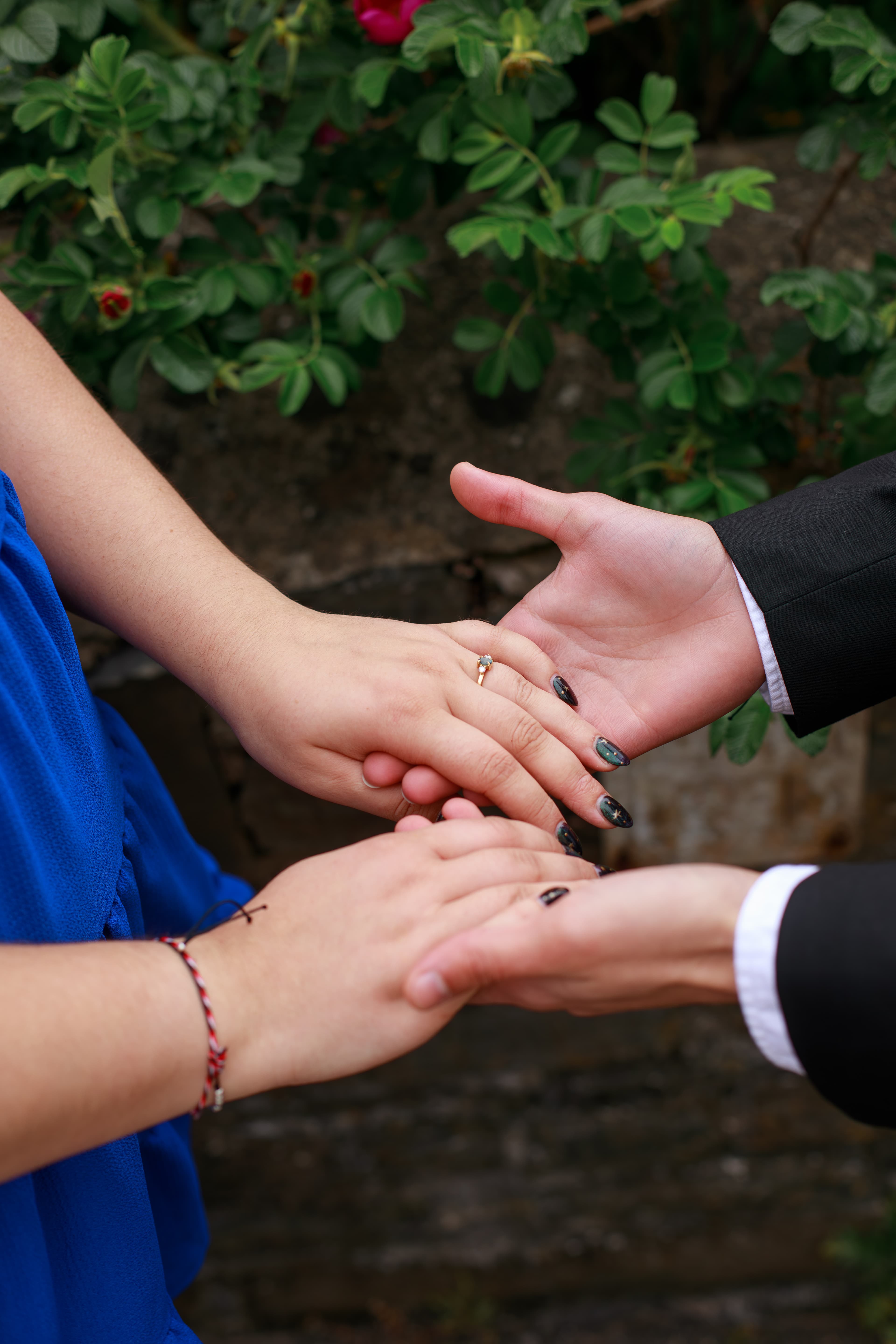 A close-up of Hannah and Bradley holding hands, showing the engagement ring